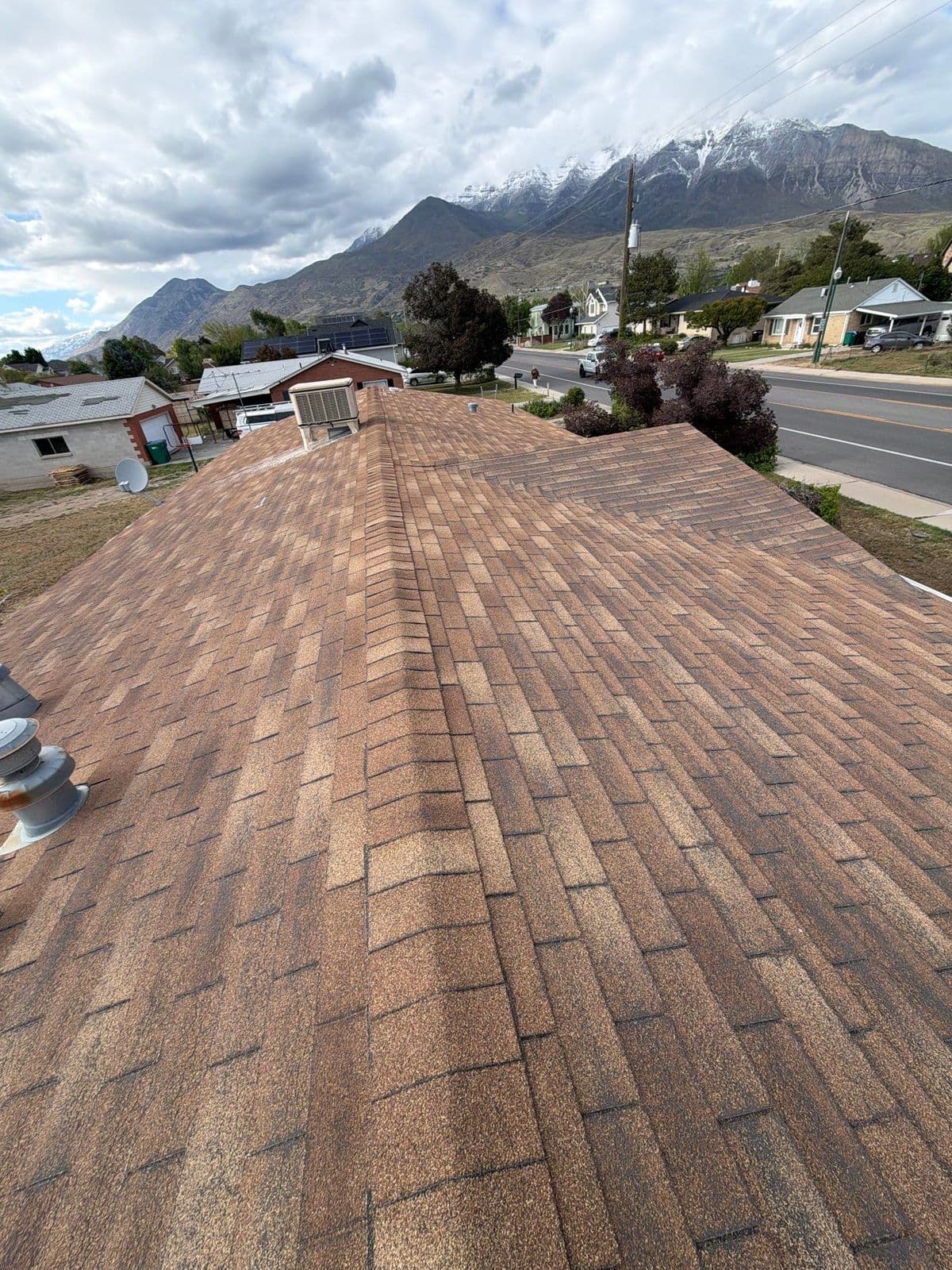 Old brown shingle roof with mountains behind
