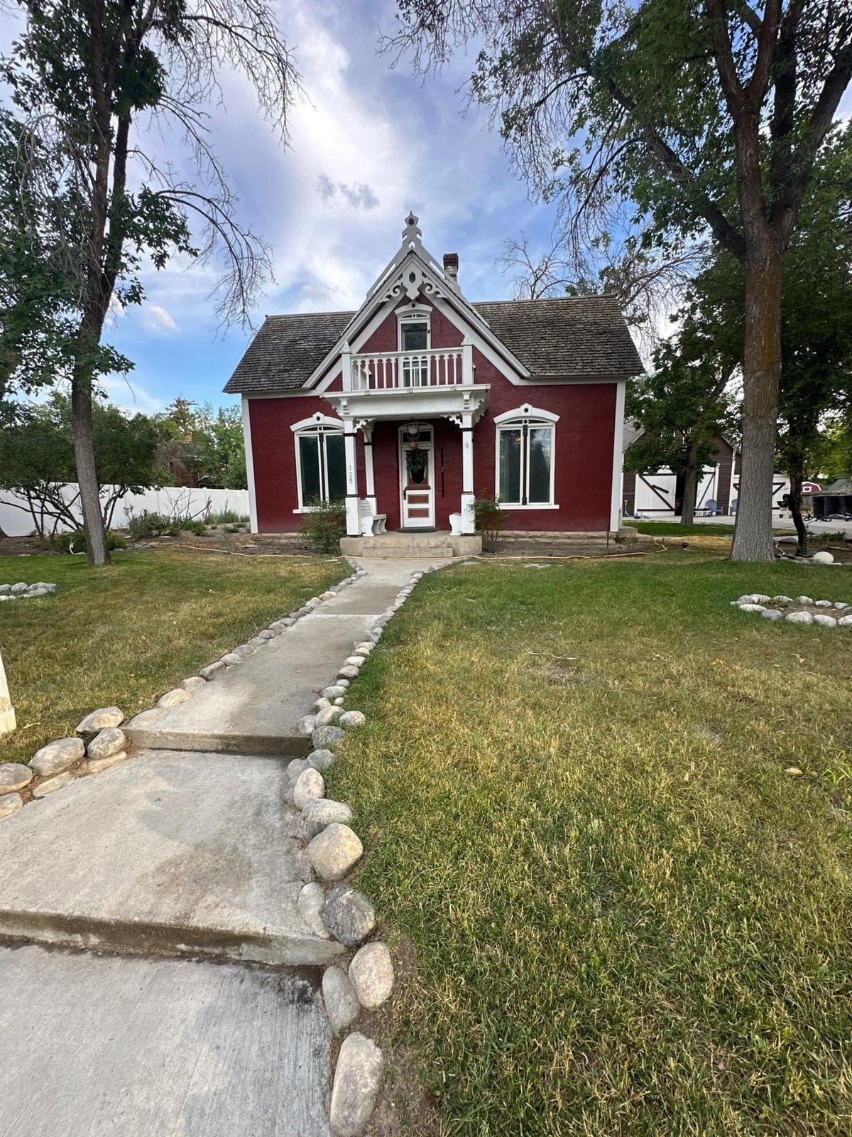 A historic red cottage in Ephraim, Utah with a worn gray cedar shake roof
