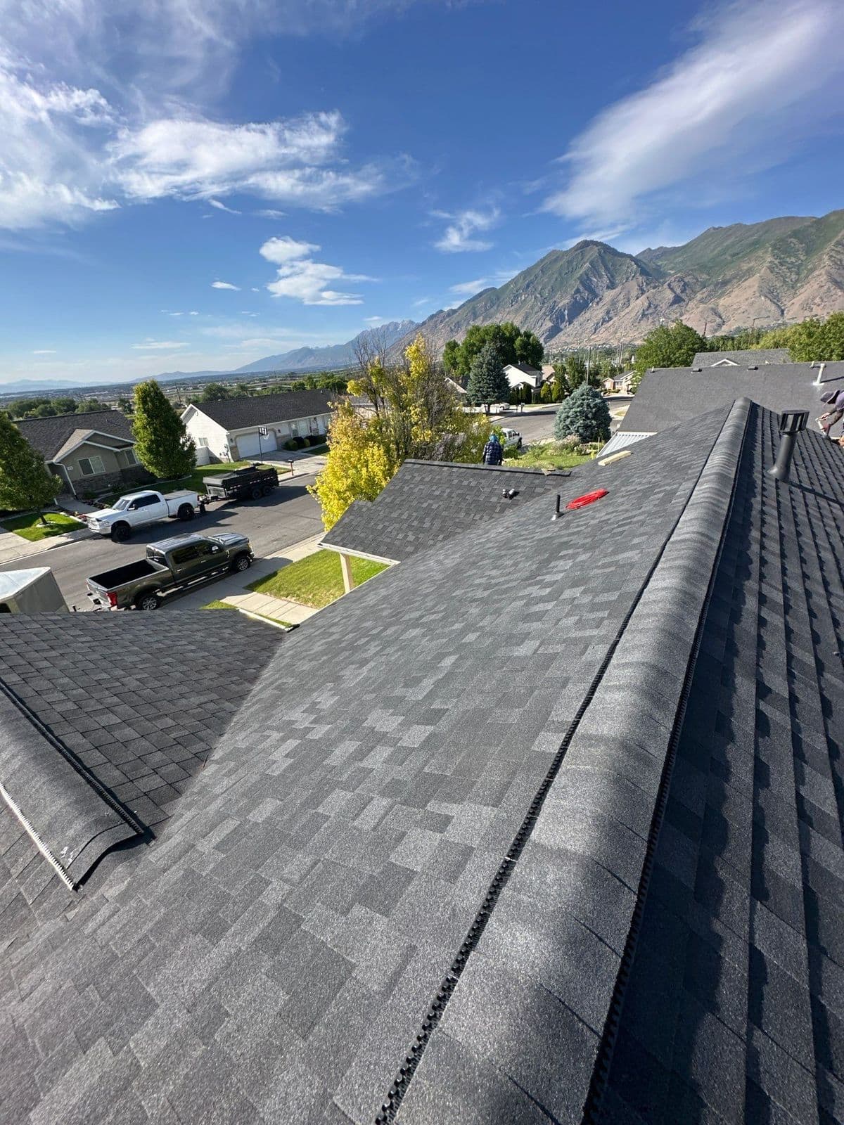 Finished grey roof along the ridge with mountains behind
